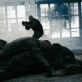 a man is laying on the floor while another man shoots