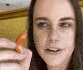 a woman with a nose ring is holding a red object in her hand
