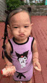 a little girl wearing a purple outfit with a cartoon character on it