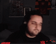 a man with a beard is waving his hand in front of a screen with a red x on it