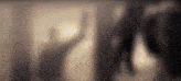 a blurred image of a person 's face behind a sliding glass door .
