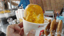 a person is holding a cup of food that says made in animotica on it