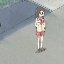 a girl in a school uniform is walking down the street