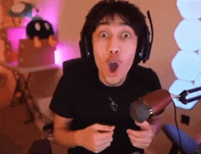 a man wearing headphones is holding a microphone and making a surprised face