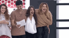 a group of people are standing next to each other and laughing . one of the people is wearing a cast on her arm .