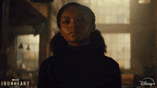 a woman in a dark room with a disney logo on the bottom right