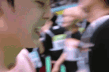 a blurred image of a person holding a bottle with a green light behind them