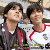 a man wearing a shirt that says seoul is sitting next to another man
