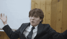 a man in a suit and tie is making a face