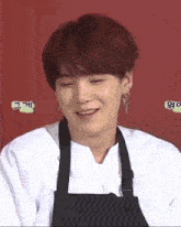 a close up of a person wearing a white shirt and an apron