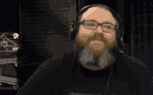 a man with glasses and a beard wearing headphones