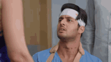 a man with a bandage on his head looks at someone