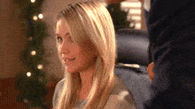 a woman with blonde hair is smiling and looking at the camera