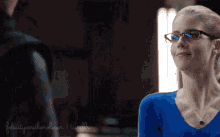 a woman wearing glasses and a blue shirt with the words felicity and heroine written on the bottom right
