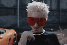 a woman wearing a black shirt and red sunglasses is smoking a cigarette