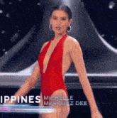 a woman in a red swimsuit with a plunging neckline is walking on a stage .