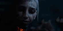 a close up of a woman 's face in a dark room with a scary face .