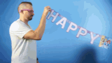 a man holds up a happy birthday banner