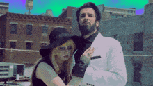 a man and a woman are standing next to each other in front of a building