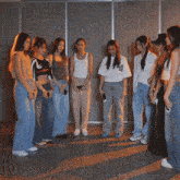 a group of young women are dancing in a room with their arms in the air