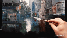 a hand is holding a spatula over a painting with the words made in animotica on the bottom