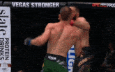 two men are fighting in a cage with a banner that says vegas stronger