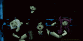 a group of dolls are dancing together in a dark room