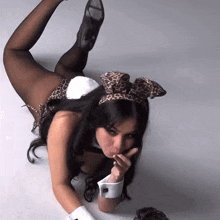 a woman in a bunny costume with a leopard print bow on her head