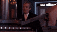 a man in a suit is standing in front of a box that says box on it