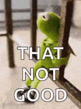 kermit the frog is sitting on a railing holding onto a railing .