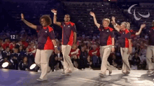 a group of people are dancing in front of a crowd with the number 121 in the corner