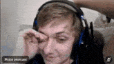 a man wearing headphones is crying while looking at the camera .