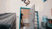 a man standing in a doorway with a sign on the door that says ' emergency exit '