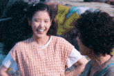 a woman in a plaid shirt is smiling next to another woman