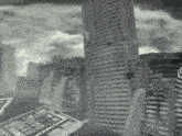 a black and white photo of a city with tall buildings and a waterfall