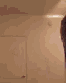 a blurry picture of a man dancing in a room with a white wall .