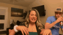 a man and a woman are sitting at a table in a living room .