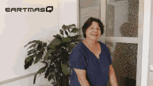 a woman stands in front of an earthmasq sign