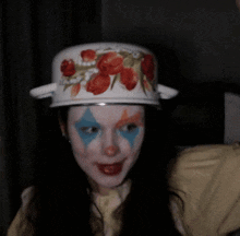 a woman wearing a hat with flowers on it is smiling