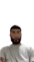 a man with a beard wearing a white shirt with his arms crossed