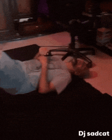 a man is laying on the floor with his feet up and the words dj sadcat below him