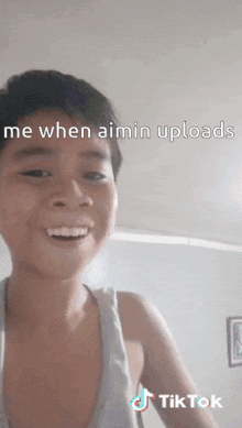 a young boy is making a funny face with the caption " me when aimin uploads "