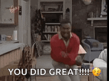 a man in a red jacket is dancing in a living room and says you did great