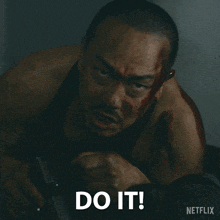 a man with blood on his face is holding a gun and the word do it is above him