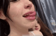 a close up of a woman 's face with her tongue hanging out .