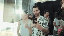a man is taking a picture of a woman with his phone .