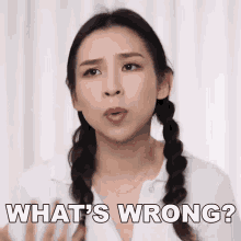 a woman with pigtails is making a face and asking what 's wrong .