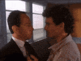 two men are standing next to each other and looking at each other