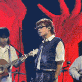 a man playing a guitar and singing on a stage