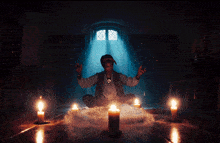 a man sits in a circle with candles and smoke